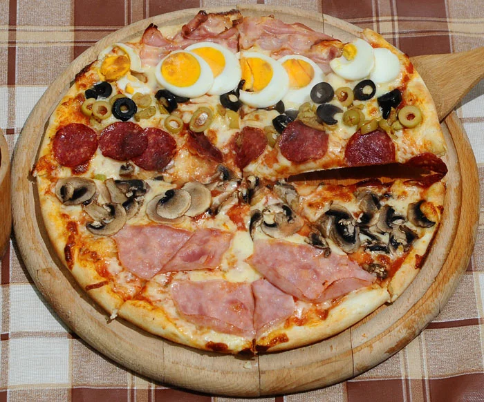 Pizza thập cẩm phủ trứng, ô liu, nấm, xúc xích và thịt nguội