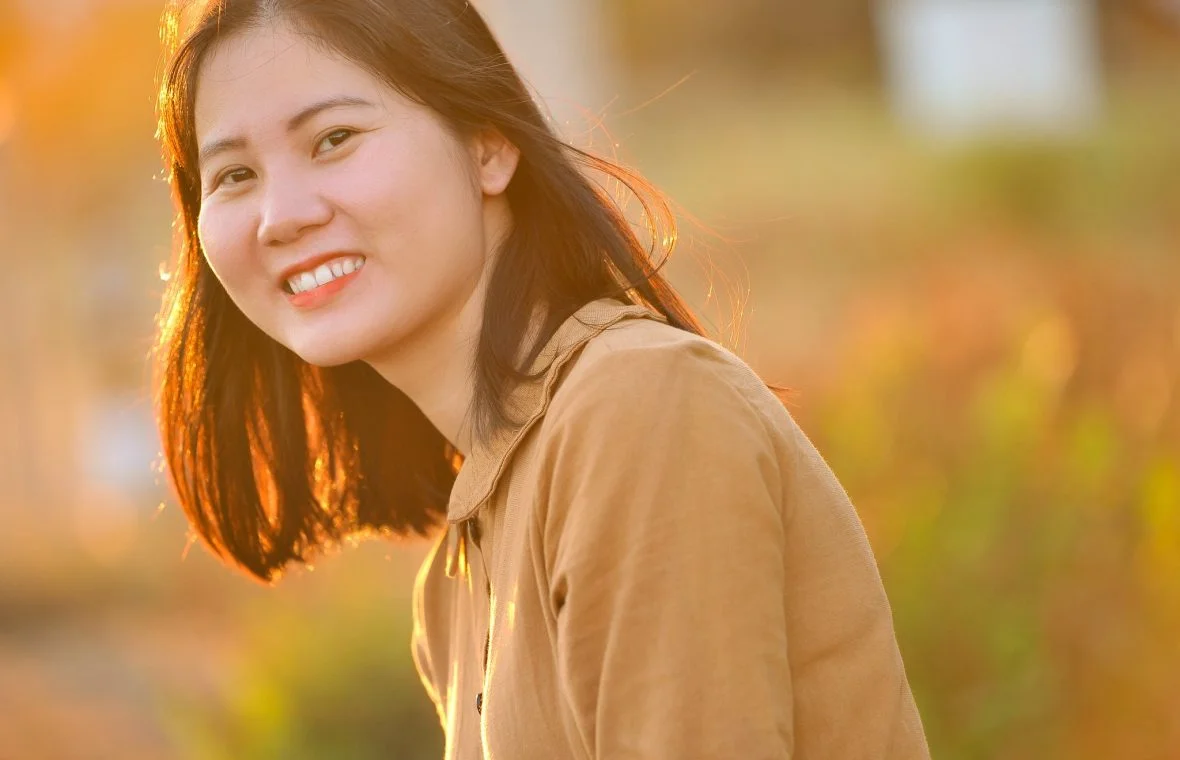 Ảnh chân dung cô gái mỉm cười trong ánh nắng ấm áp