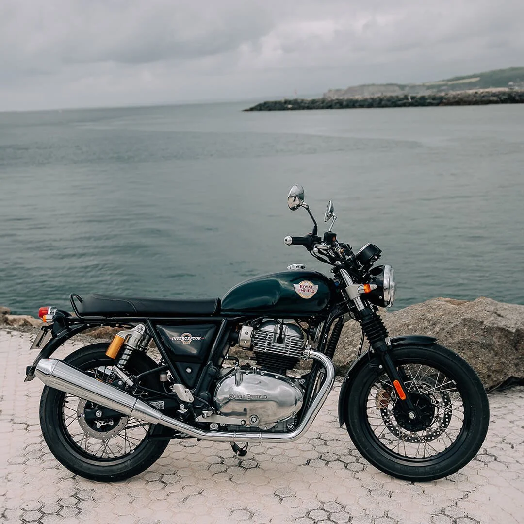 Hình nền đẹp ngầu với xe mô tô Royal Enfield màu xanh đậm bên bờ biển